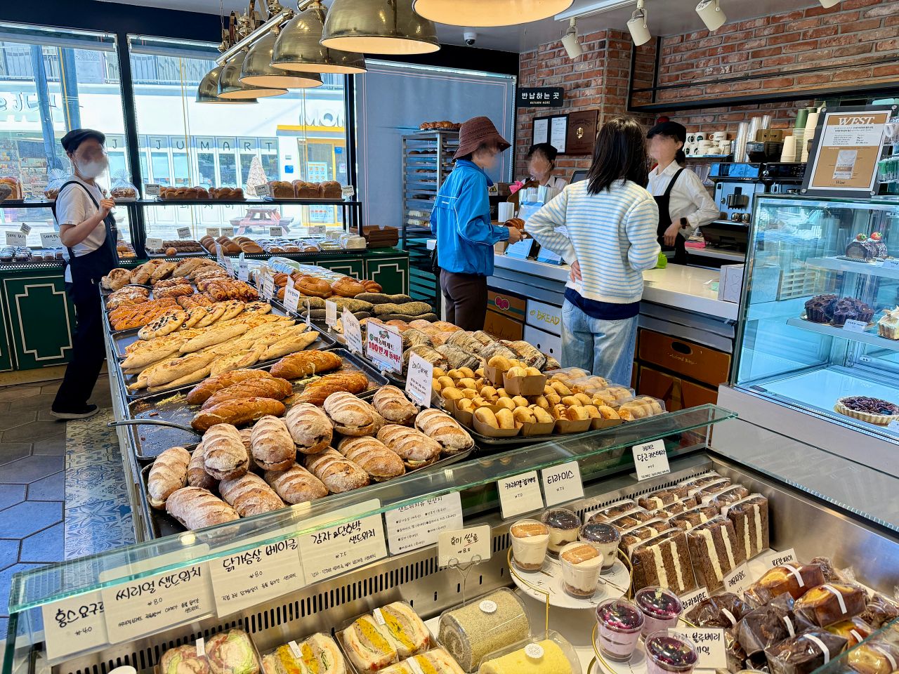 濟州島大蒜麵包 Audrant Bakery 攻略|咸德本店招牌大蒜麵包、出爐時間、分店資訊與怎麼帶回台灣 - 第1張圖 Audrant Bakery 剛出爐補貨的大蒜麵包擺滿烤盤,不少韓國人進店外帶