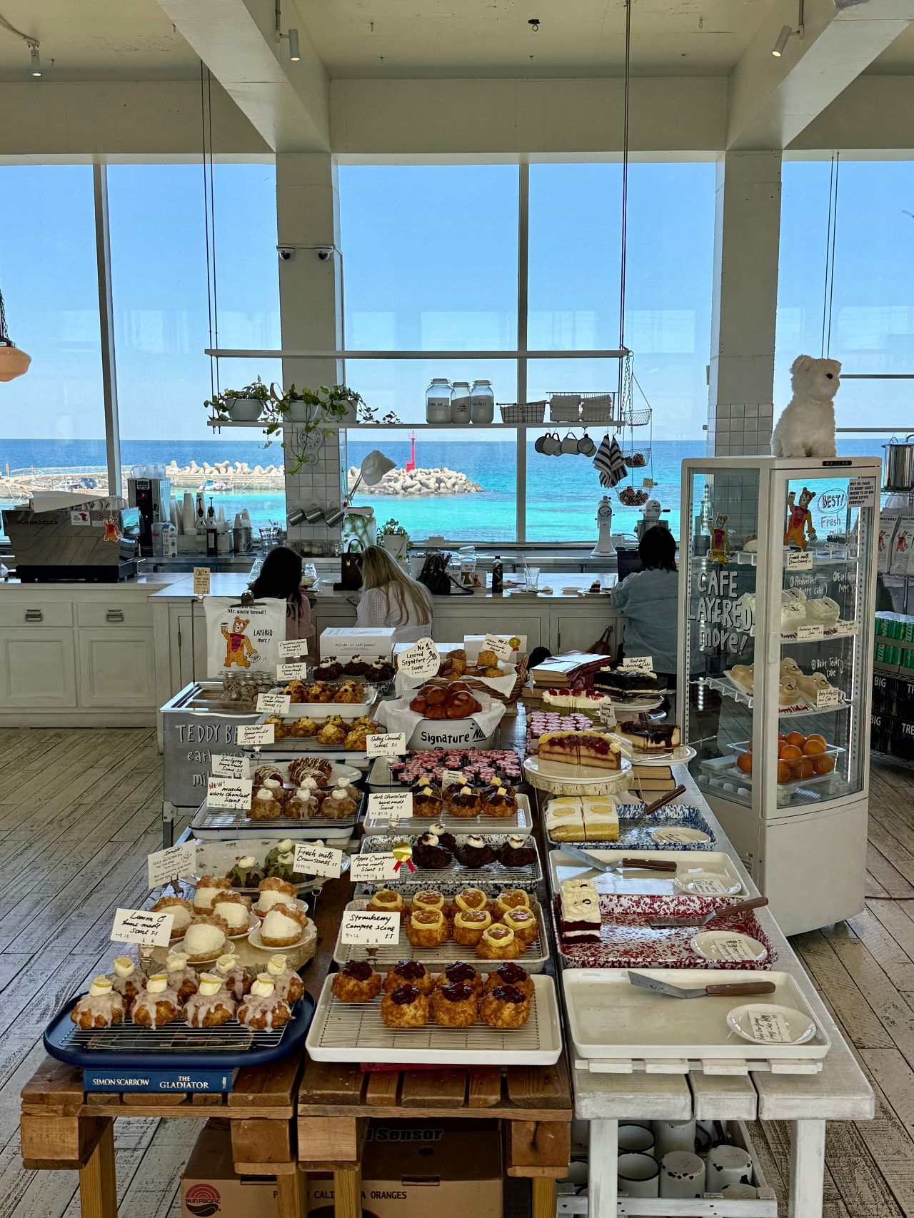 Cafe Layered 濟州店攻略|倫敦貝果隔壁的海景咖啡廳,司康、分店、交通停車一次看 - 第2張圖 Cafe Layered 濟州店的大面落地窗海景座位,窗外是藍色海景
