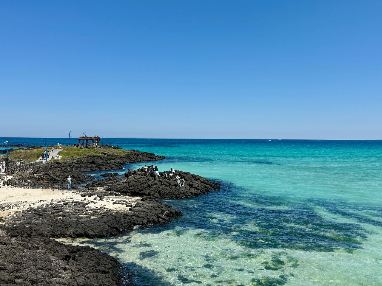 咸德海水浴場攻略|濟州島東岸自駕第一站,停車、海景、日落全收錄 - 第1張圖 咸德海水浴場的白沙灘與漸層藍海水