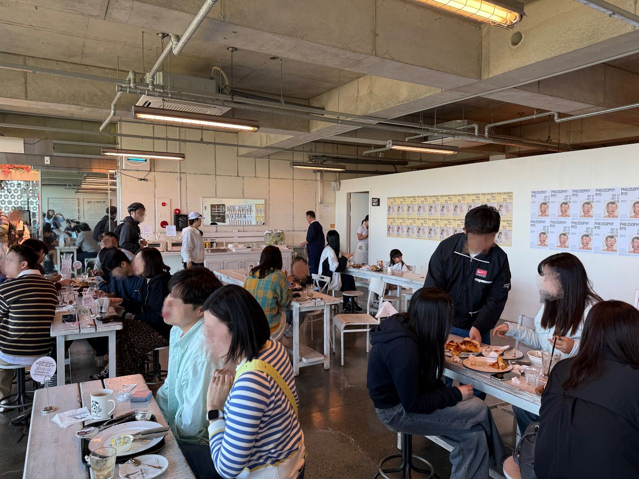 濟州島倫敦貝果博物館的用餐座位區，工業風水泥天花板與白色長桌